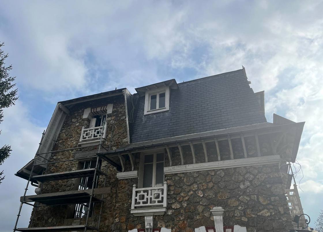 Maison en pierre sous échafaudage pendant la réfection de sa toiture en ardoise, chantier de Couv'Tal, couvreur à Talange